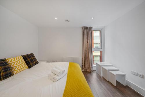 a bedroom with a white bed with towels on it at Spacious Modern 1-Bedroom Flat in Central London in London