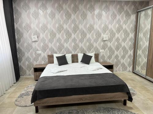 sypialnia z łóżkiem i ścianą w obiekcie Motel Xameleon w mieście Voznesensk