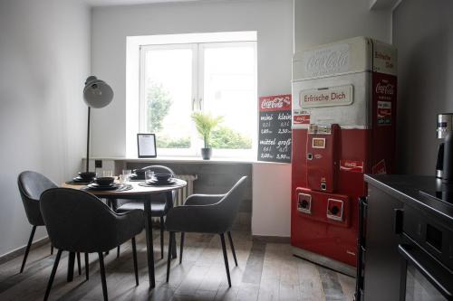 - une salle à manger avec une table et un réfrigérateur rouge dans l'établissement Industrie Loft 1902 - Gratis Parken - Zentral, à Wilhelmshaven