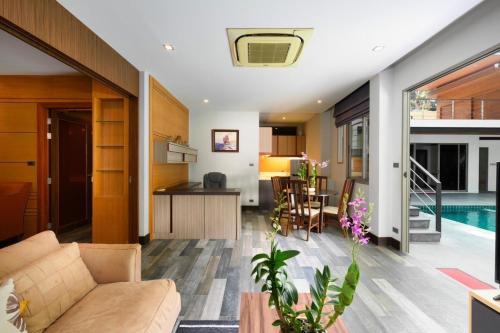 a living room with a couch and a kitchen and a pool at Villa Pattara Rawai in Ban Saiyuan (1)