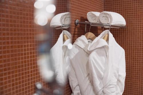 a group of white towels hanging on a rack at Selinunte Boutique Hotel in Marinella di Selinunte