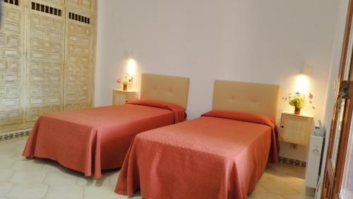 2 Betten in einem Hotelzimmer mit roter Bettwäsche in der Unterkunft Cortijo de la luna la casita in Taramay