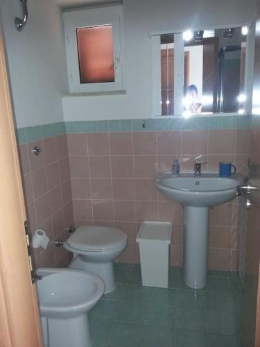a bathroom with a sink and a toilet and a mirror at Casa vista mare in San Nicola Arcella