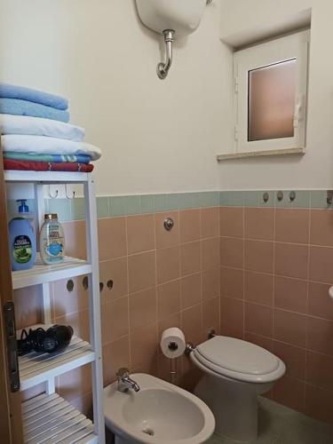 a bathroom with a toilet and a sink and towels at Casa vista mare in San Nicola Arcella