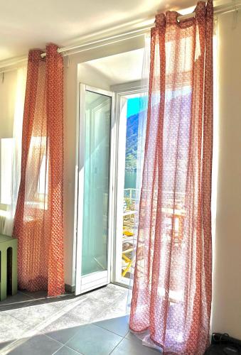 an open window with curtains in a room at La casa sulla collina - apt. 1 in Colonno