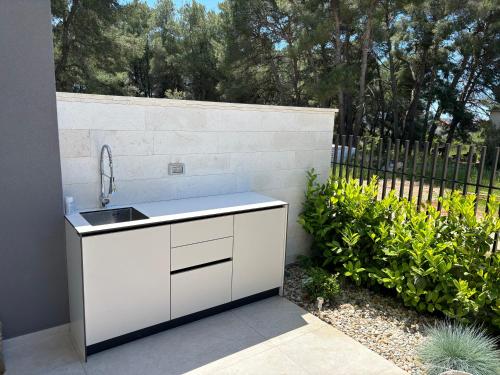 a white kitchen with a sink in a garden at Villa Nika in Bibinje