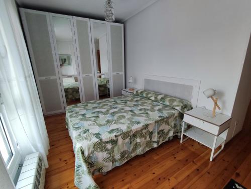 a bedroom with a bed and a table with a night stand at Laredo-Colindres in Colindres