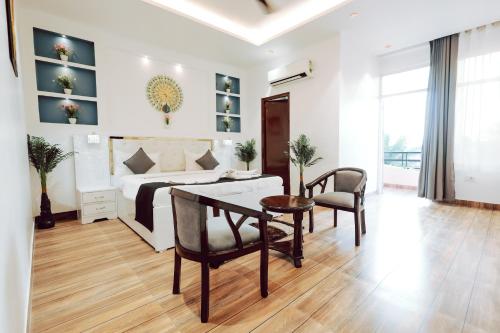 a living room with a bed and a table and chairs at Elegance Resort in Vrindāvan