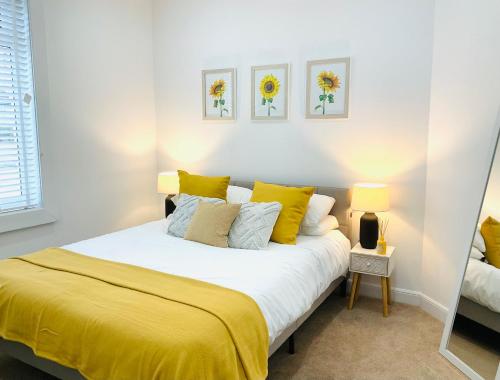 um quarto com uma cama grande com lençóis amarelos em Harling House em Prestwick