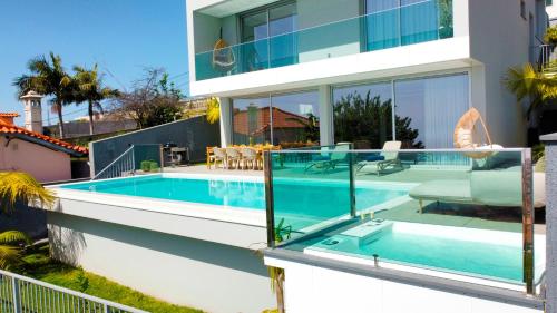 a house with a swimming pool and a house at Villa Obra-Prima by LovelyStay in Funchal