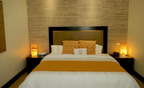 a bedroom with a large bed with two lamps at Hausuites in Mexico City