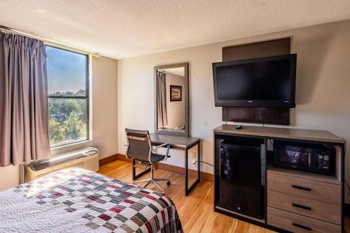 Westwood的住宿－High Point Inn & Suites，配有一张床和一台平面电视的酒店客房