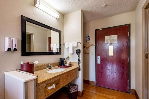 Westwood的住宿－High Point Inn & Suites，一间带水槽和红色门的浴室