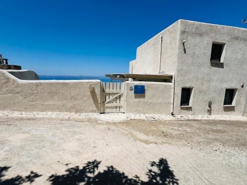 a building with the ocean in the background at Pasithea House in Ioulis