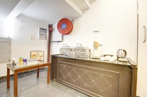 a kitchen with a counter and a table and a clock at Hotel Devrana Delhi in New Delhi