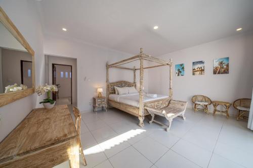 um quarto com uma cama de dossel, uma mesa e cadeiras em Villa Santi - New & Modern 2 Bedroom Villa Seminyak em Seminyak