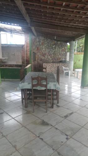 a table and chairs in a room with a stone wall at Silone Araújo in Pau dʼAlho