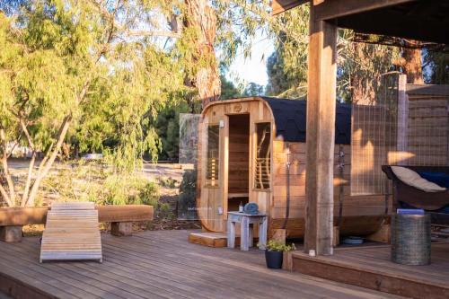 a wooden out house on a deck with a bench at Torquay Bliss Retreat with Sauna and Hot Tub in Torquay