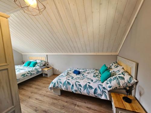 1 Schlafzimmer mit 2 Betten und Holzdecke in der Unterkunft Kominkówka in Brenna