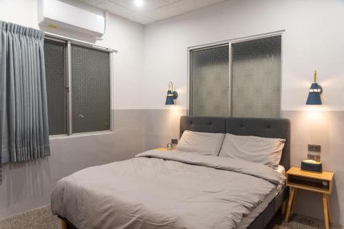 a bedroom with a bed and two windows at 圈圈宿QQs & 三點不陋SDBL in Longjing