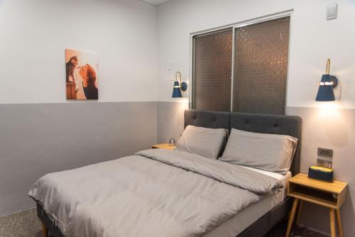 龍井區的住宿－圈圈宿QQs & 三點不陋SDBL，一间卧室配有一张带白色床单的床和一扇窗户。