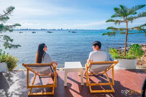 two people sitting at a table looking at the water at Baan Sailboat Beach Kohlarn in Ko Larn