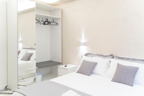 a white bedroom with a bed and a mirror at Tom Luxury Home in Fondi