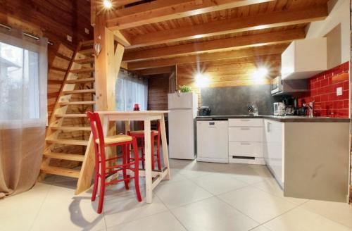 cocina con nevera, mesa y sillas en Maison d'une chambre avec jardin amenage et wifi a Yssingeaux a 3 km des pistes, en Yssingeaux