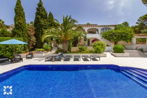 a swimming pool in front of a house at Villa Corasol by Abahana Villas in Teulada