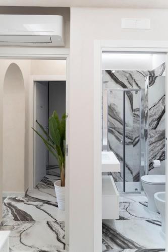a bathroom with marble flooring and white fixtures at Tom Luxury Home in Fondi