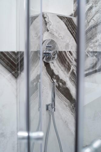a shower with a hose in a bathroom at Tom Luxury Home in Fondi
