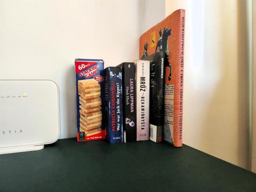 a row of books sitting on a shelf at Studio Centrum, Private Entrance, SELF CHECK-IN 24h in Katowice