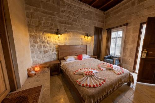 a bedroom with a bed and a stone wall at Feris Cave Hotel in Nevsehir