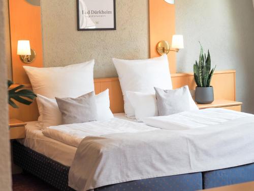 um quarto com 2 camas com lençóis brancos e almofadas em Weinstraße No 8 "Einfach-Gut-Übernachten" em Leinsweiler