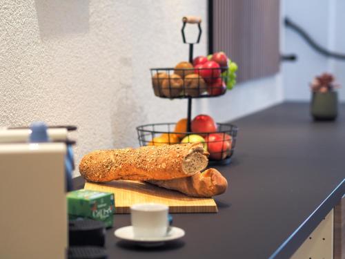 eine Theke mit Brot und Äpfeln und einem Obstkorb in der Unterkunft Weinstraße No 8 "Einfach-Gut-Übernachten" in Leinsweiler