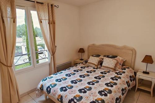 a bedroom with a bed and a window at Lou Olivie, appartement climatisé avec piscine aux pieds Alpilles in Paradou