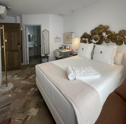 サアラ・デ・ロス・アトゥネスにあるCasapuerta El Refugioのベッドルーム1室(大きな白いベッド1台、タオル付)