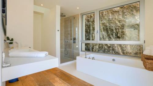 a bathroom with a shower and a sink and a window at Rock Villa in Pollença