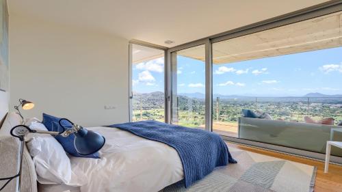 a bedroom with a bed and large glass windows at Rock Villa in Pollença
