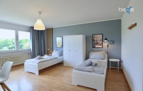 1 dormitorio con 2 camas y armario blanco en BEGE APARTMENTS Executive Lodgings, en Duisburg