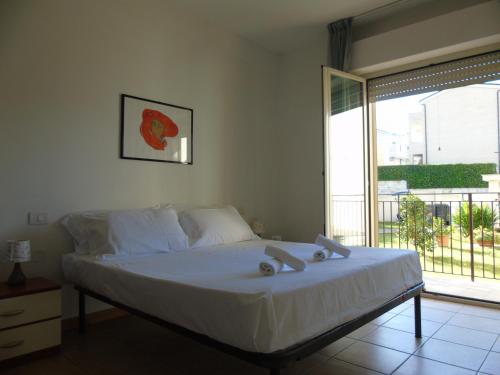 a bedroom with a bed and a large window at Homiday - Appartamenti Tamerici in Pineto