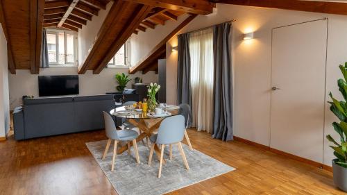 een eetkamer en een woonkamer met een tafel en stoelen bij Magic Place Bergamo! Appartamento Relax con terrazza nel cuore di Bergamo in Bergamo