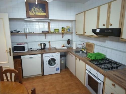 a kitchen with a washer and a stove top oven at Lamedos in San Luis de Sabinillas