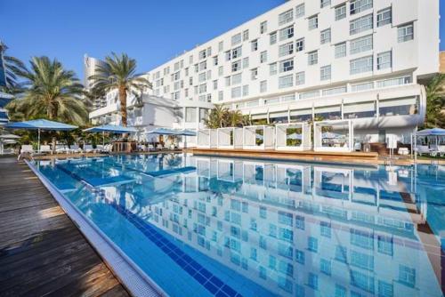 a large swimming pool in front of a hotel at Noga by Isrotel Collection - The Renewed Ganim Hotel in Ein Bokek
