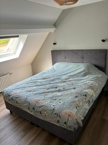 a bedroom with a bed with a blue comforter at Vakantiehuis Klaartje Kip Enschede tot 4 personen, landelijk gelegen! in Enschede