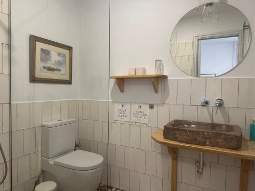 uma casa de banho com um WC, um lavatório e um espelho. em Casapuerta El Refugio em Zahara de los Atunes