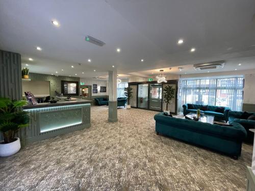 a large living room with blue couches and a kitchen at Ruskin Hotel in Blackpool