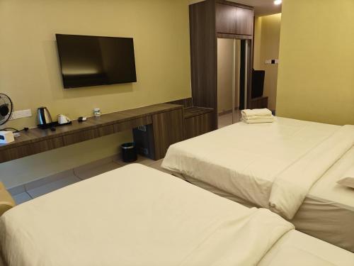 a hotel room with two beds and a flat screen tv at Grand Ion Delemen by 91 Homestay in Genting Highlands