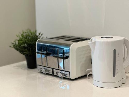 a toaster sitting on a counter next to a coffee maker at Cozy 1 bedroom at Olympic Park with one carspace in Sydney