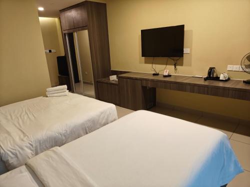 a hotel room with two beds and a flat screen tv at Grand Ion Delemen by 91 Homestay in Genting Highlands